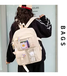 Vista posteriore dettagliata di uno zaino Oxford bianco crema con tasche e badge decorativi