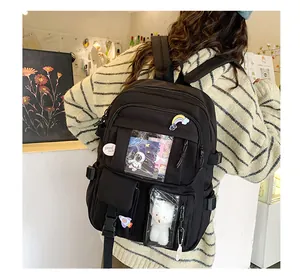 Dettaglio dello zaino in nylon nero con finestra in PVC trasparente e ciondolo a orsetto