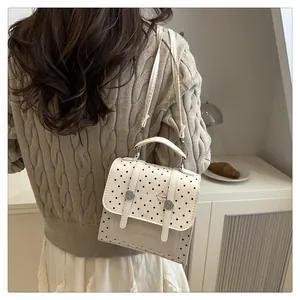 Detailaufnahme des weißen Polka-Dot-Rucksacks mit Zierriemen und Burger-Cartoon-Muster