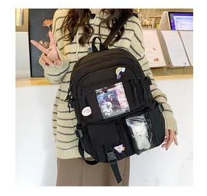 Dettaglio dello zaino oxford nero con tasca trasparente a finestra e badge decorativi