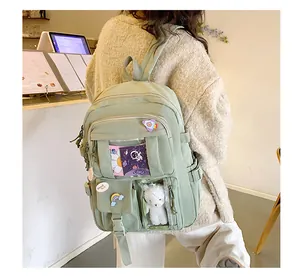 Dettaglio dello zaino in nylon verde chiaro con finestra in PVC e ciondolo a orsetto