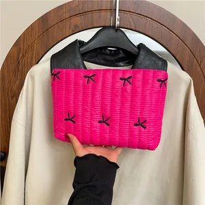 Gesteppte rosarote Handtasche mit schwarzen Schleifenstickereien und Ledergriff im Design