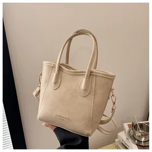 Detail of beige lychee texture tote bag with gold lettering and adjustable shoulder strap