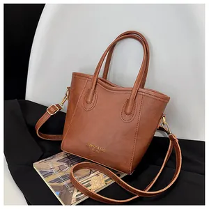 Detail of vintage brown leather handbag featuring golden logo text and texture