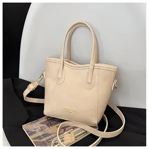 Detail of off-white leather tote bag with gold logo and adjustable shoulder strap