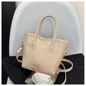 Detail of cream white faux leather tote bag with Fashion & Bag EST.1985 text and gold hardware