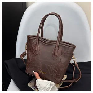 Macro shot of dark brown retro leather texture and golden brand logo on a handbag