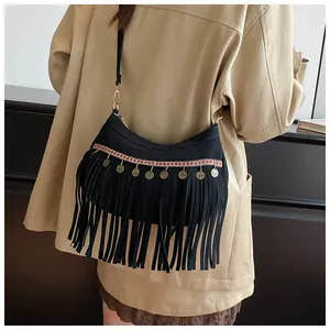 Détail du sac bohème avec broderie ethnique et charms en forme de pièces métalliques