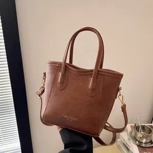 Brown vintage faux leather tote bag with gold lettering and adjustable shoulder strap