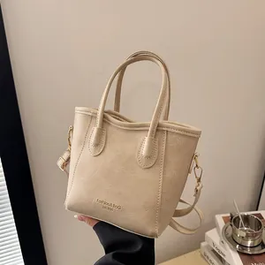 Chic cream leather bucket handbag with gold lettering and adjustable shoulder strap