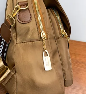 Close-up of smooth golden zippers and durable brown nylon fabric on a stylish backpack