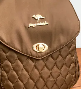 Close-up of brown waterproof nylon backpack with quilted pattern and golden metal lock