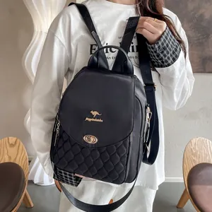 Detail of black backpack with diamond quilted stitching and golden kangaroo metal clasp