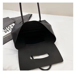 Macro view showing spacious interior and pocket of this black minimalist leather tote bag