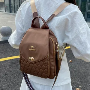 Detail of dark brown backpack featuring quilted pattern and golden kangaroo metal logo