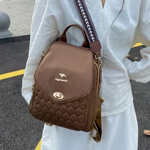 Detail of a brown quilted backpack with a metal twist lock and ethnic jacquard strap