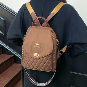 Rear view of a model wearing the brown quilted nylon backpack on a wooden staircase
