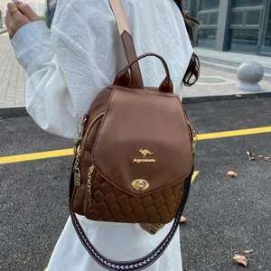 Detail of dark brown backpack with diamond quilted pattern and kangaroo metal logo