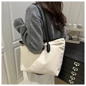 Cream large tote bag with black straps worn by model for office and daily casual style