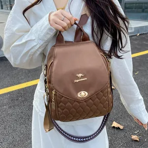 Close-up of brown quilted backpack with golden kangaroo logo and ornate wide strap