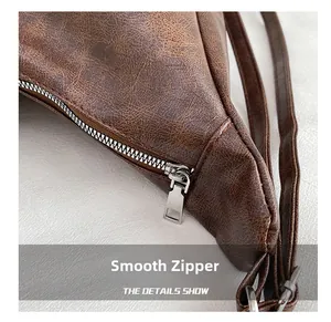Close-up of smooth silver metal zipper on vintage brown leather tote bag detail