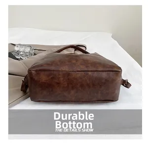 Detail view of the wear-resistant flat bottom and stitching on this brown tote bag
