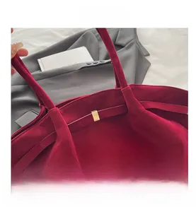 Close-up of deep red velvet tote bag showing high-quality texture and gold metal buckle