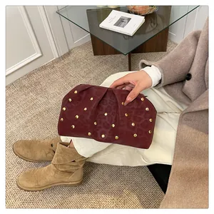 Macro view of burgundy ruched clutch bag with gold studs and subtle leopard pattern