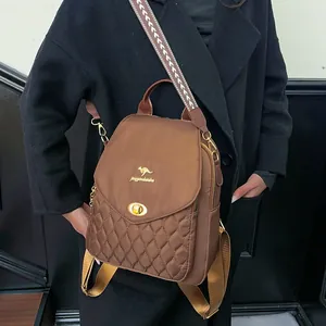 Close-up of brown quilted nylon backpack with gold kangaroo logo and wave pattern strap