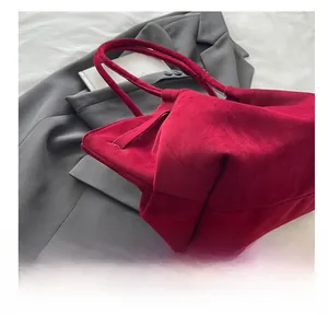 Detail of burgundy matte tote bag with unique folded design and suede-like texture