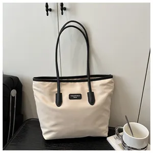 Detailed view of large tote bag with contrast black trim and rectangular logo patch