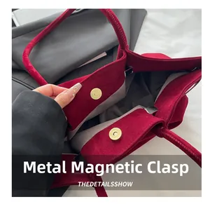Detail view of the red matte tote bag featuring a golden metal magnetic snap closure