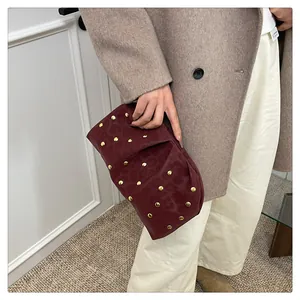 Macro view of burgundy pleated clutch featuring gold rivets and leopard pattern details