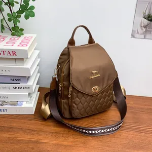 Detail of brown quilted nylon backpack with golden kangaroo logo and patterned strap