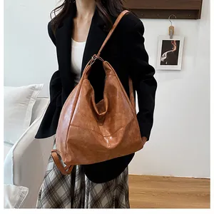 Detail of vintage brown leather tote bag with pleated stitching and adjustable strap
