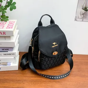 Close-up of black quilted backpack with golden kangaroo logo and adjustable woven straps