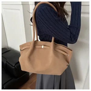 Detail of a caramel frosted tote bag with decorative strap and golden metal buckle