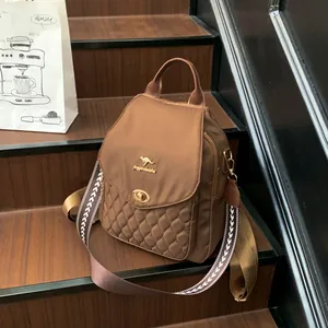 Detail of brown quilted nylon backpack featuring golden kangaroo logo and woven strap