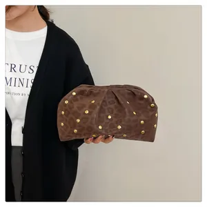 Detail of leopard print clutch with gold studs and elegant pleated leather texture