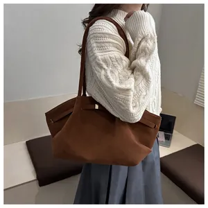 Detail view of brown matte suede tote bag with side decorative strap and metal buckle