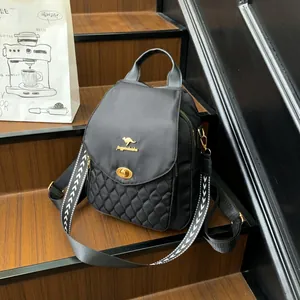 Detail of black nylon backpack featuring diamond quilting and geometric woven strap