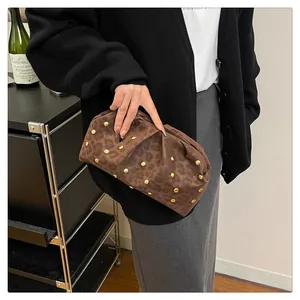 Detailed shot of brown leopard print ruched clutch bag with decorative gold studs