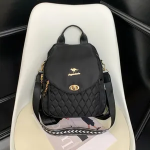 Detail of black quilted nylon backpack featuring golden kangaroo logo and metal lock