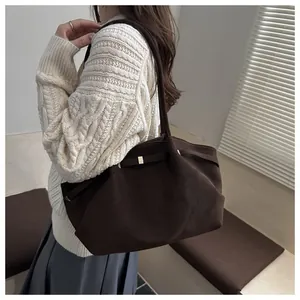 Detail of dark brown matte tote bag with elegant gold metal hardware for winter style
