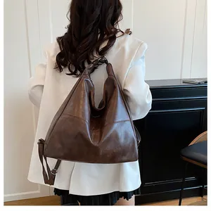 Detailed view of the dark brown leather tote bag showing texture and adjustable strap