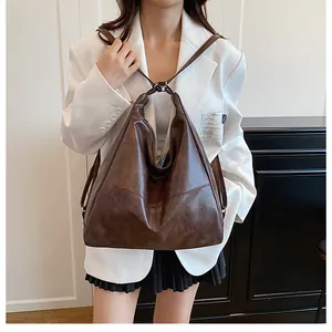 Detailed texture of dark brown vintage PU leather on a large tote bag with knotted handles