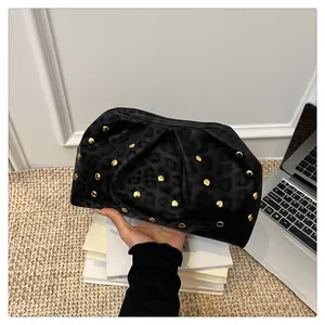 Detail of black leopard print clutch bag with gold studs and pleated cloud design