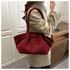 Detail of burgundy frosted leather tote bag showing soft suede texture and metallic buckle