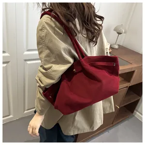 Macro view of the large burgundy suede tote bag showing premium matte texture and side buckle