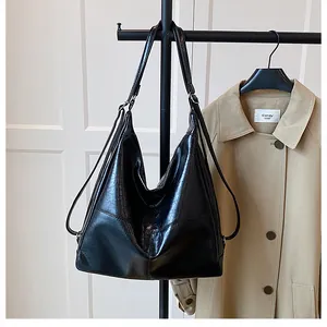 Close-up of a large black faux leather tote bag with stylish cross stitching detail